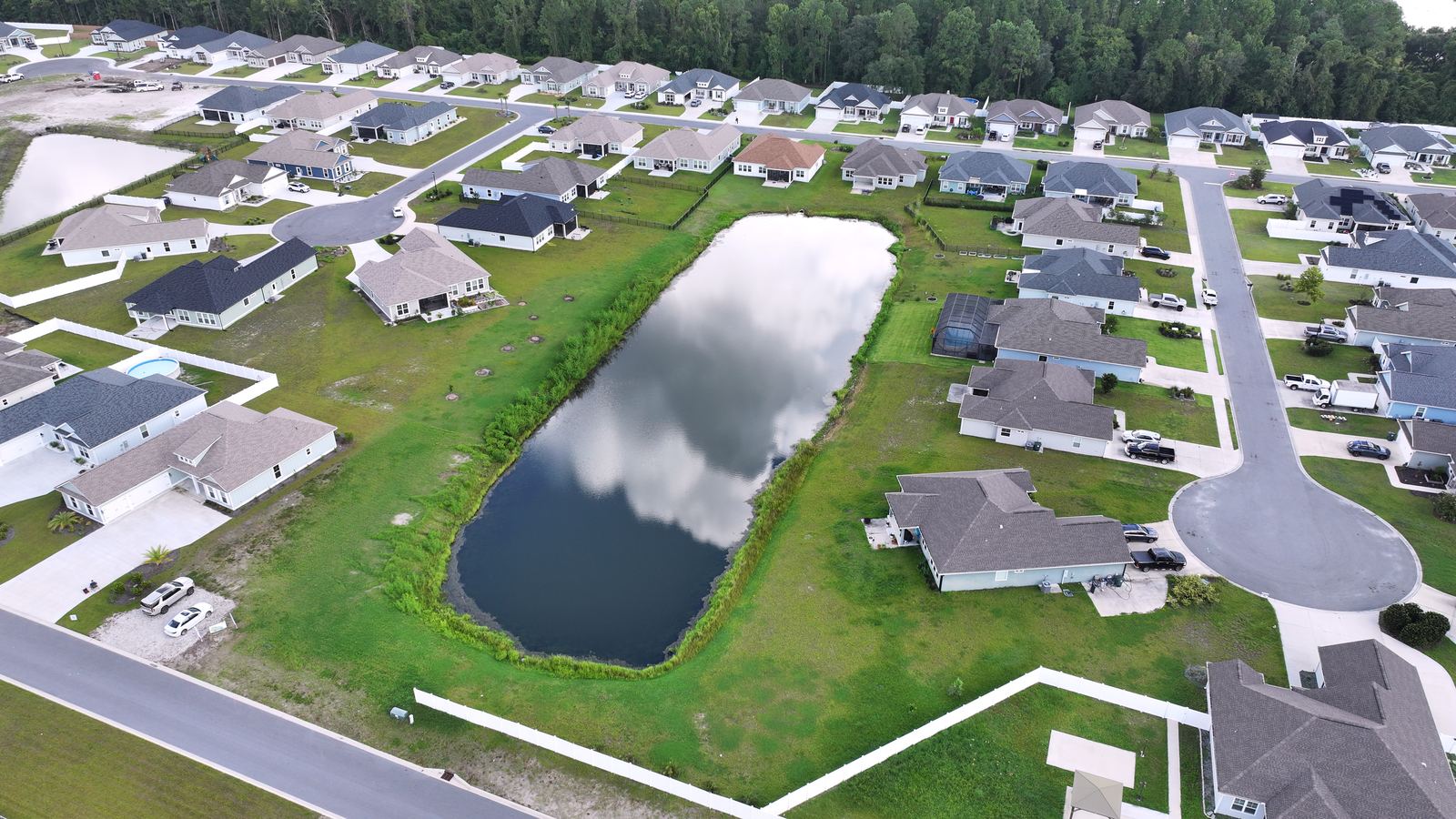 Aerial of a new construction community and retention pond